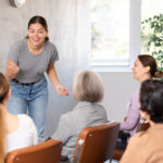 Positive young girl giving lecture to group of women