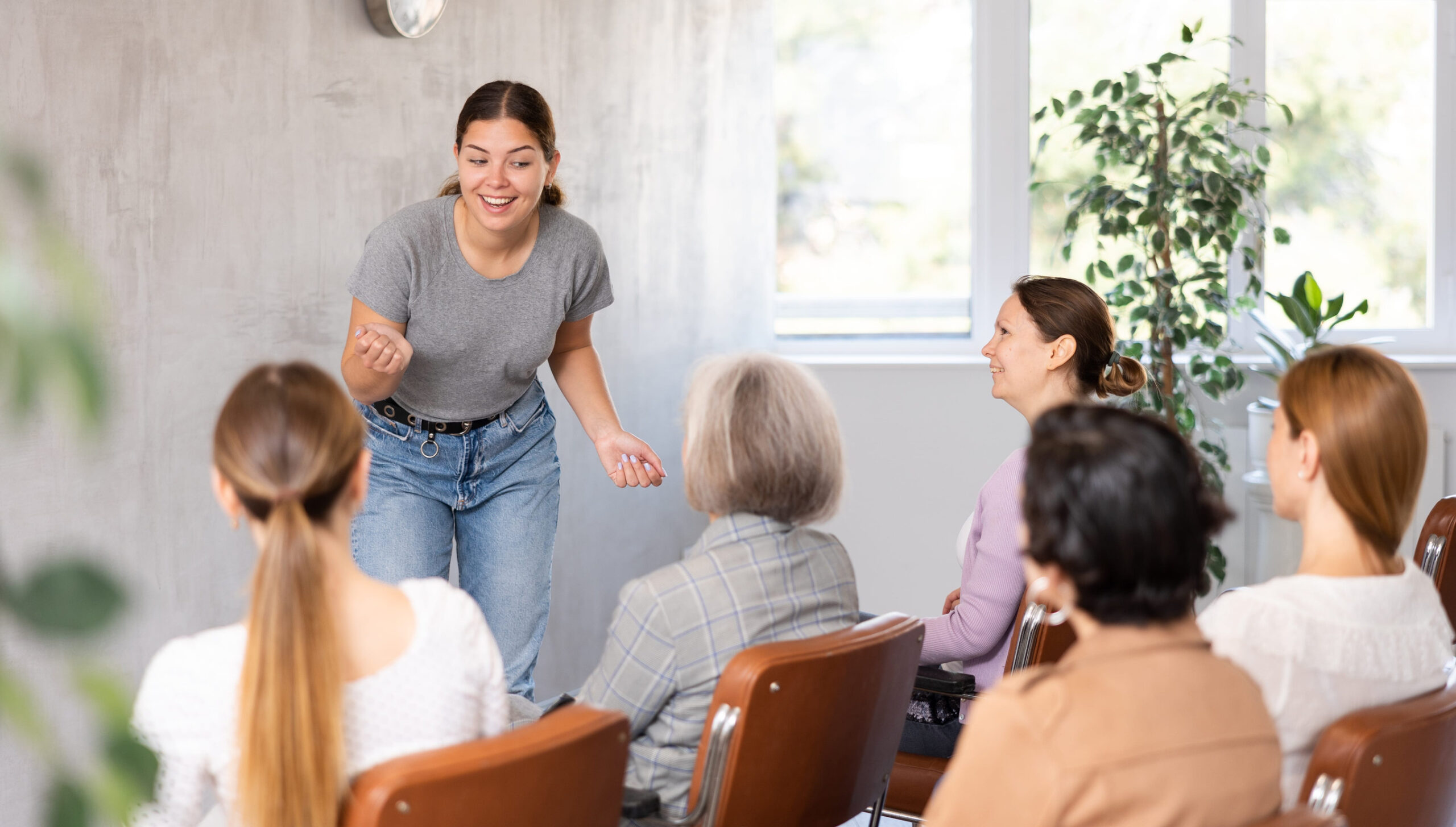 Positive young girl giving lecture to group of women